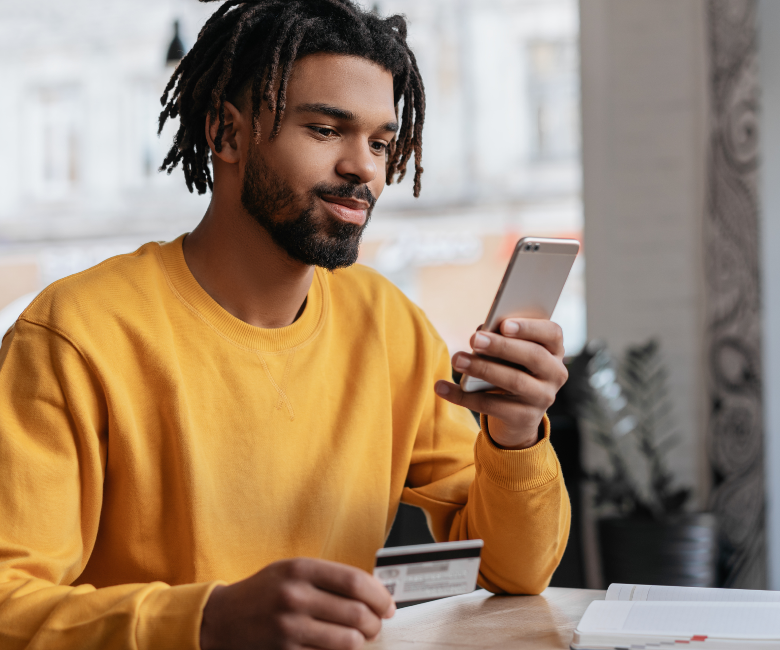 a man in a yellow sweater looking at his phone